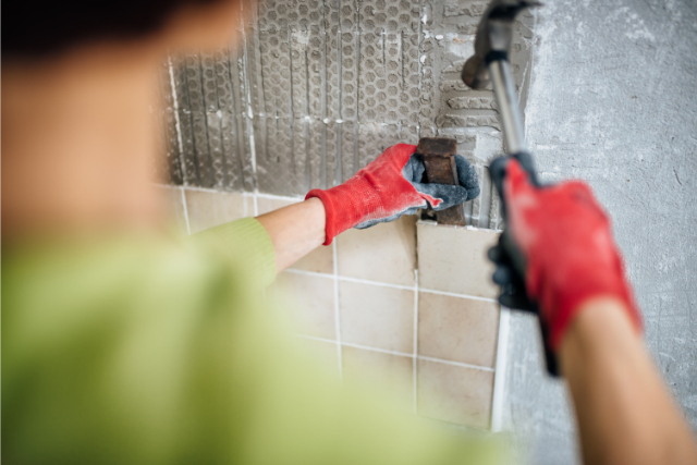 Hillsboro Tile Replacement by worker in Hillsboro with a hammer and chisel